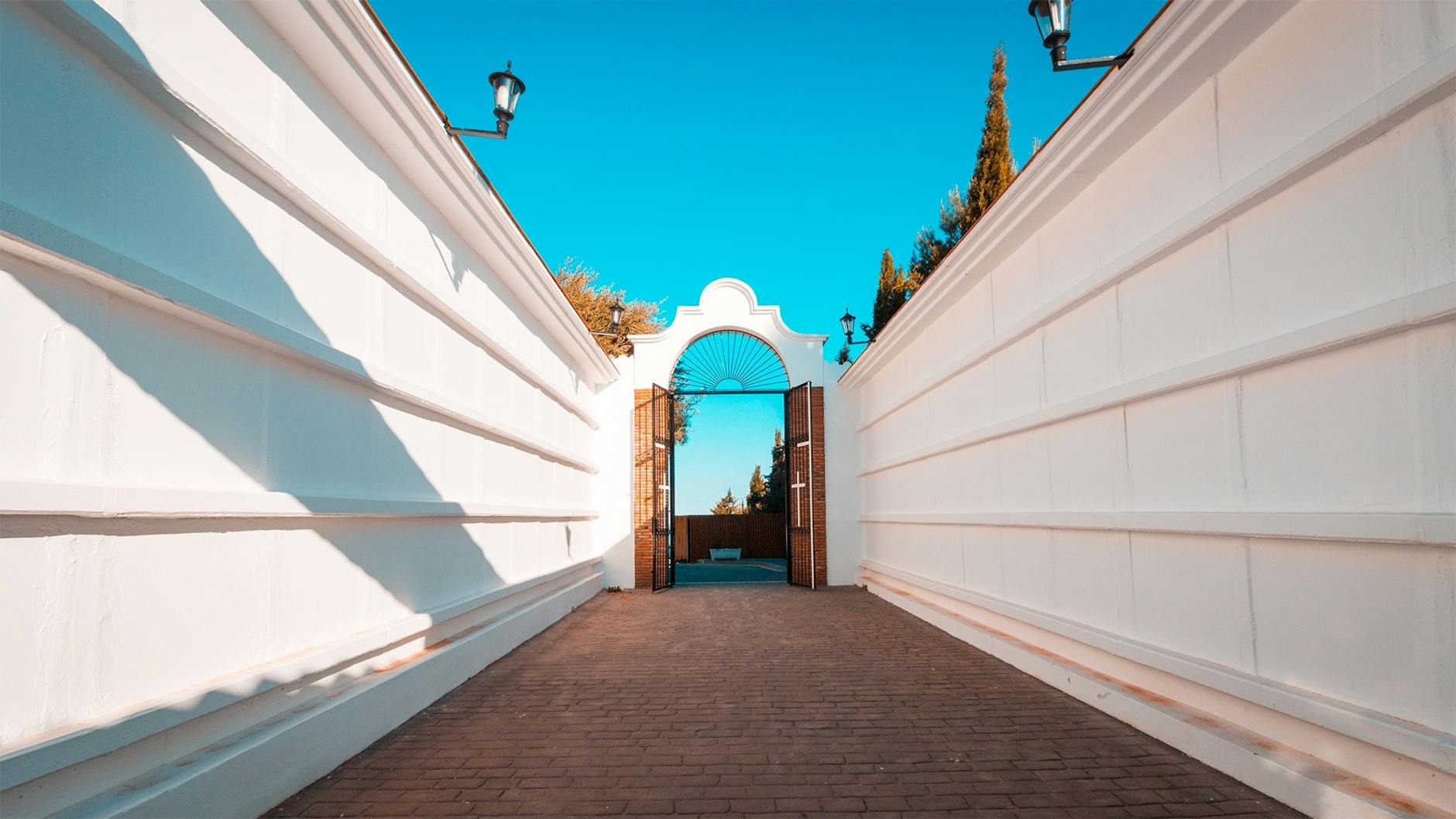 empty pathway in between white wall